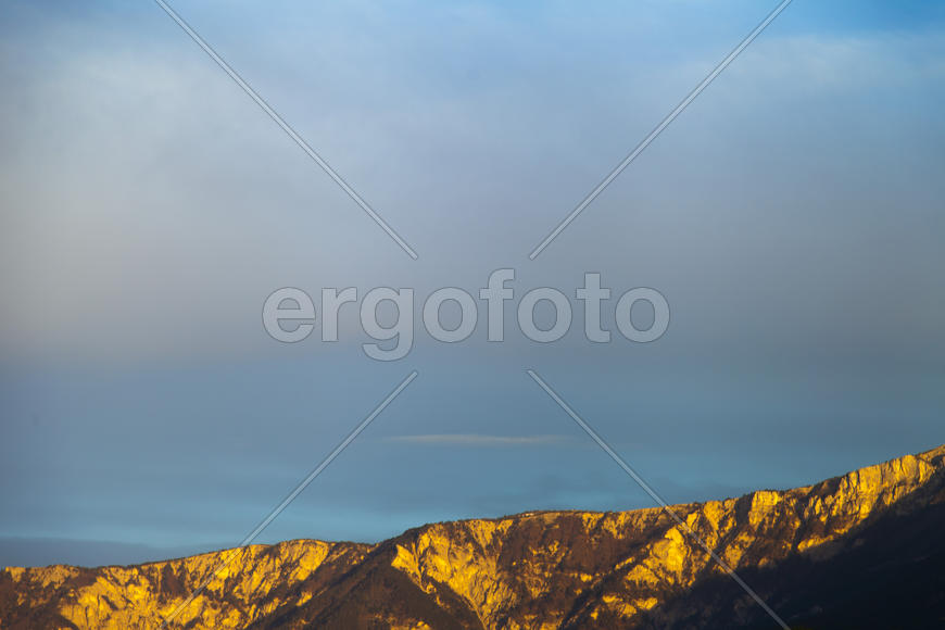 Mountains by the sea in beams of a bright sun