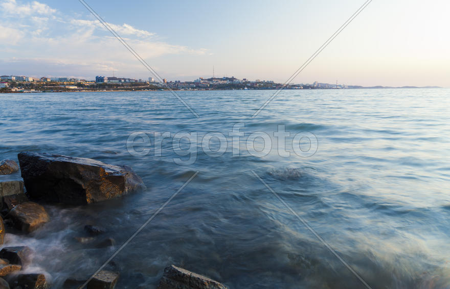 The sea at sunset in beams of the red setting sun