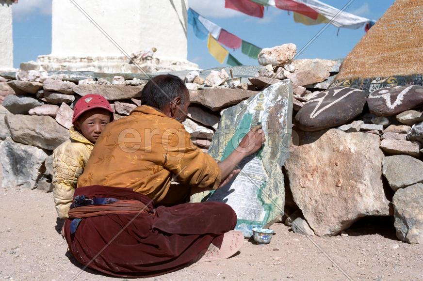 Пожилой тибетский лама учит внука рисовать