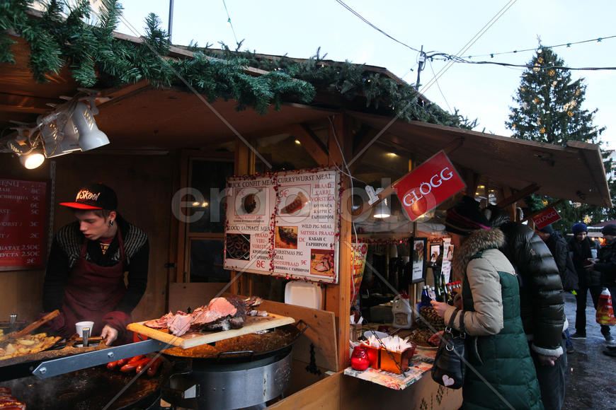 На рождественском рынка на Ратушной площади В Таллинне посетители покупают традиционную эстонскую ед