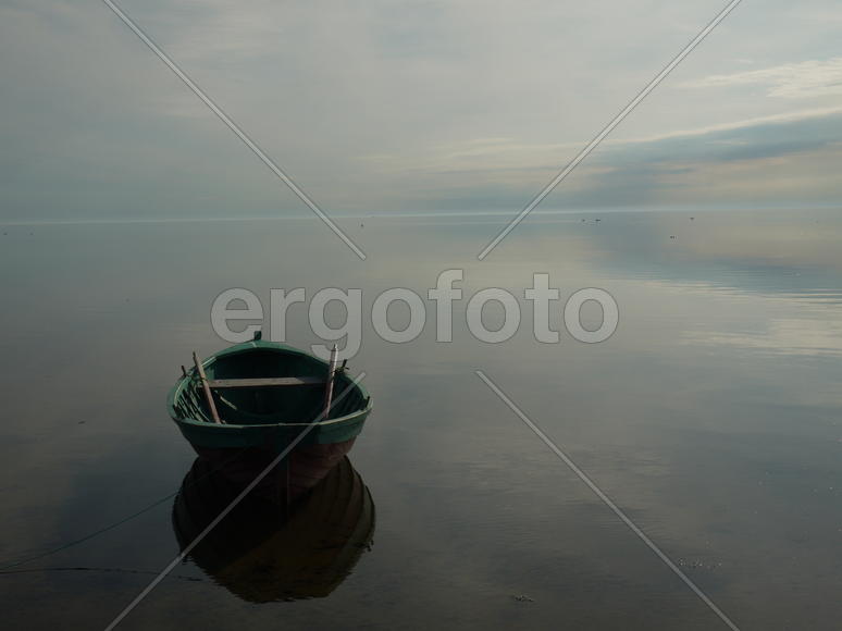 Лодка на водяной глади во время заката 