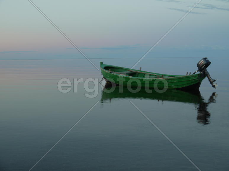 Лодка на водяной глади во время заката 