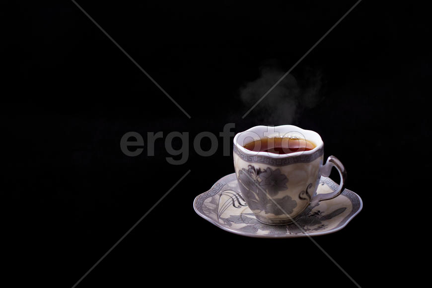 Чашка горячего чая на чёрном фоне