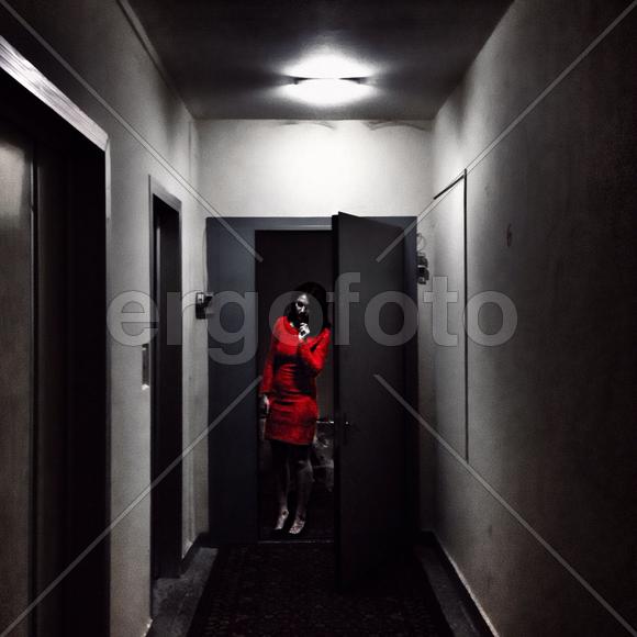 Девушка в красном платье ждет прихода госте на Новый год