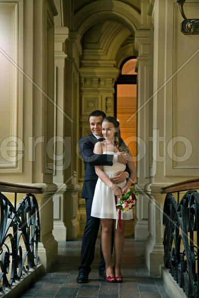 жених и невеста обнимаются на балконе Гума