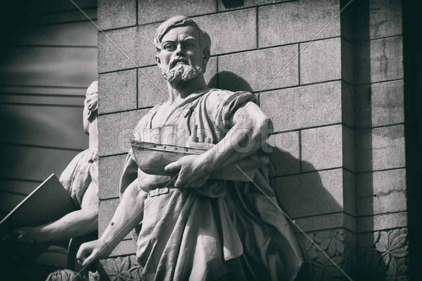 Скульптура мужчины с моделью парохода в руке