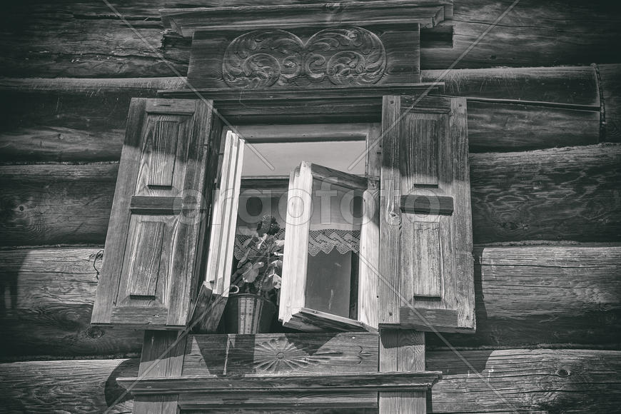 Окно с резными ставнями в деревянном доме из сруба. Россия 