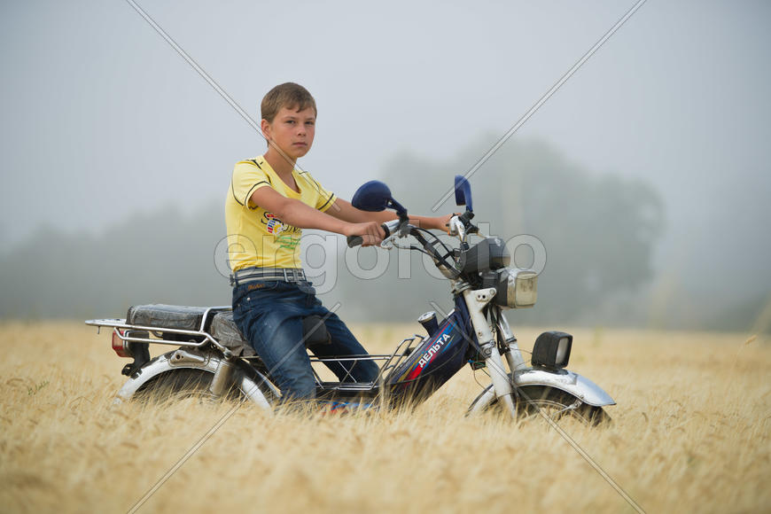 Мальчик катается на мотоцикле