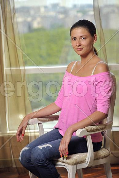портрет девушки в розовом, сидящей на стуле