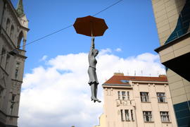 Висящая скульптура женщины под зонтом