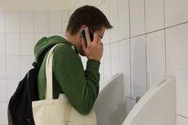 Человек разговаривает по телефону в туалете