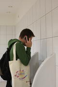 Молодой человек в туалете говорит по телефону
