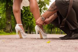 Жених застегивает туфельку невесте