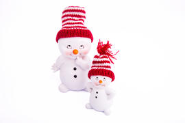 Новогодние снеговички в ярких шапках на белом фоне