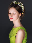 Девушка в зеленом платье с цветочным венком в волосах