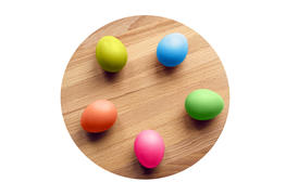 colorful easter eggs on a circular wooden board isolated
