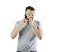 Frightened man talking on the phone isolated on a white background