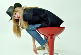 Девушка в шляпе на красном стуле