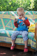 Мальчик есть печенье на диване