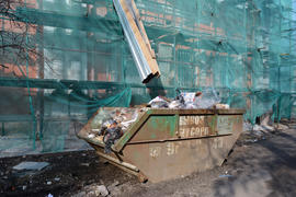 Контейнер для мусора на строительной площадке. На контейнере сделана надпись - вывоз мусора