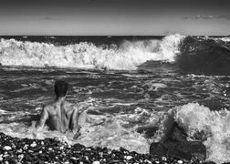 Мужчина на побережье Чёрного моря днём в шторм, Крым