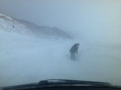 Мужчина расчищает дорогу от снега в метель 