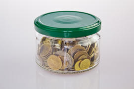 Металлические монеты разного достоинства в стеклянной банке