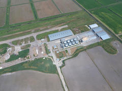 Plant for the drying and storage of grain. Rice plant in the middle of fields. Top view.