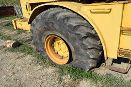 Broken flat tire on a large tractor. Damaged wheels.