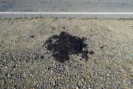 The piece of fresh asphalt which dropped out on a roadside. Repair of the road