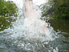 The man jumping in water. It is a lot of water splashes