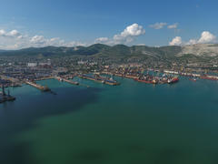 Industrial seaport, top view. Port cranes and cargo ships and barges. Loading and shipment of cargo 