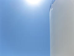 White tank in the sun. Equipment for primary oil refining