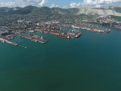 Industrial seaport, top view. Port cranes and cargo ships and barges. Loading and shipment of cargo 