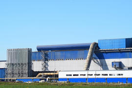 Big plant for processing scrap metal. Huge factory old metal refiner. Blue roof of the factory build