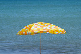 оранжевый зонтик на берегу моря 