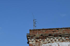 The television antenna on the rooftop. Means of reception of a signal