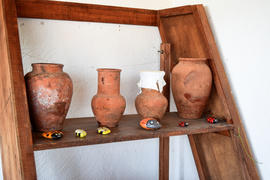 Глиняные и керамические горшки на деревянной этажерке 
