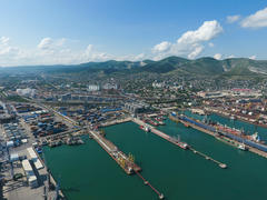 Промышленный морской порт, вид сверху. Портовые краны и грузовые суда и баржи