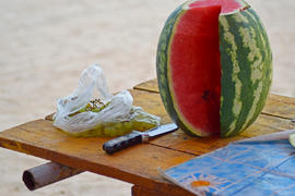 Cut watermelon with grapes on the table. Consumption of fruit on vacation
