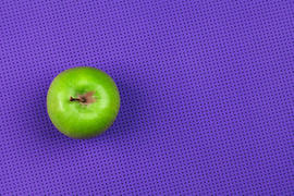 Яблоко на фиолетовом фоне