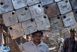 Man carries empty cans on his head in Mumbai