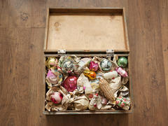 Wooden box of old Christmas toys wrapped in newspaper
