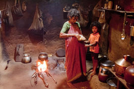 Woman with child preparing food in the kitchen of the rural homes