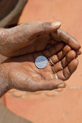 Hand holding a coin in a beggar one rupee