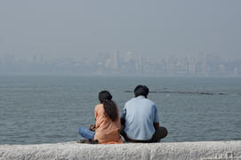 Young couple sitting on the promenade in Mumbai