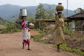 Woman carries water in a jar home