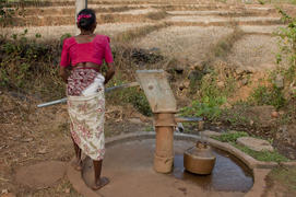Woman collects water in a jug from the column in an Indian village