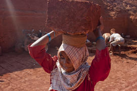 Indian woman carries the red stone building in the quarry