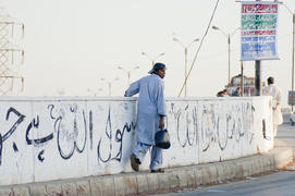 Boy goes along a road in Karachi